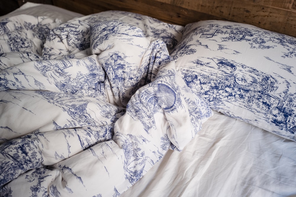 blue and white pillow on white bed